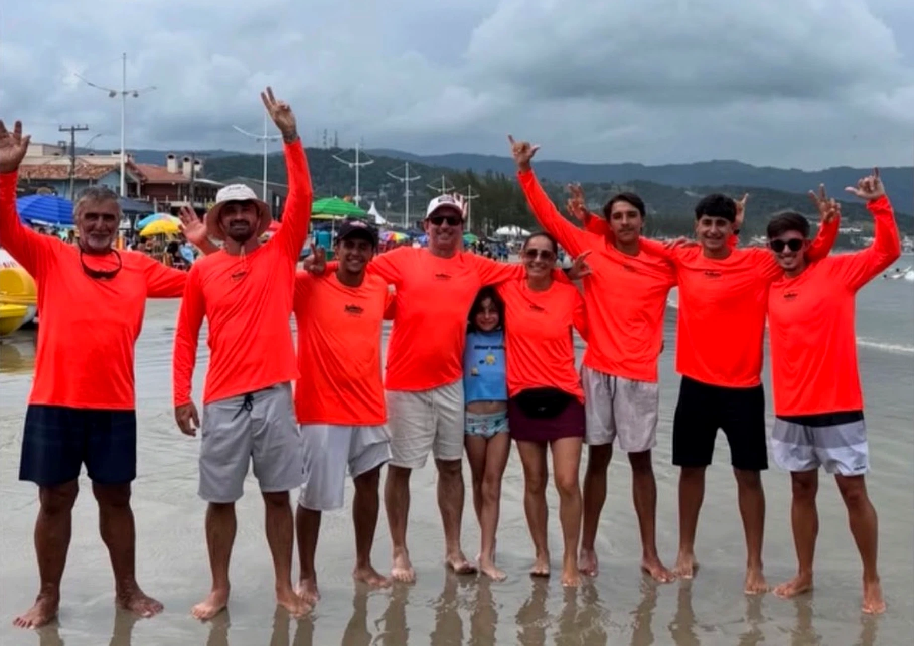 Equipe de camisa laranja na Praia de Garopaba
