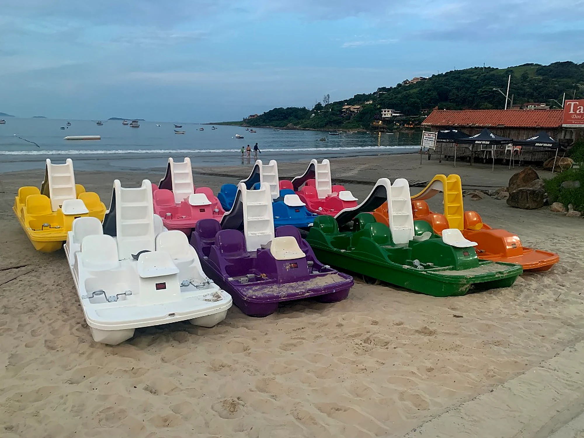 Pedalinhos coloridos com escorregador na areia